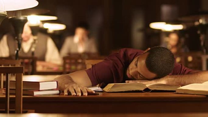 DS年轻男学生在图书馆看书时睡着了
