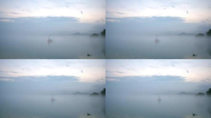 雾天宁静湖水上的小渔船