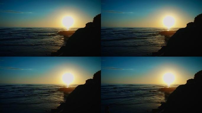 相机用广角镜头锁定，展示了美丽的夏日日落，海浪慢慢滚滚而来。