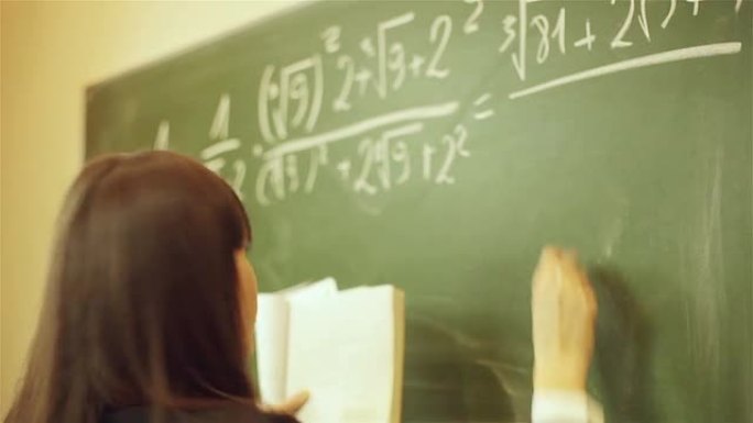 女孩在黑板上写数学方程