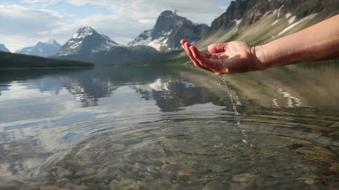 人的手在山湖里舀水