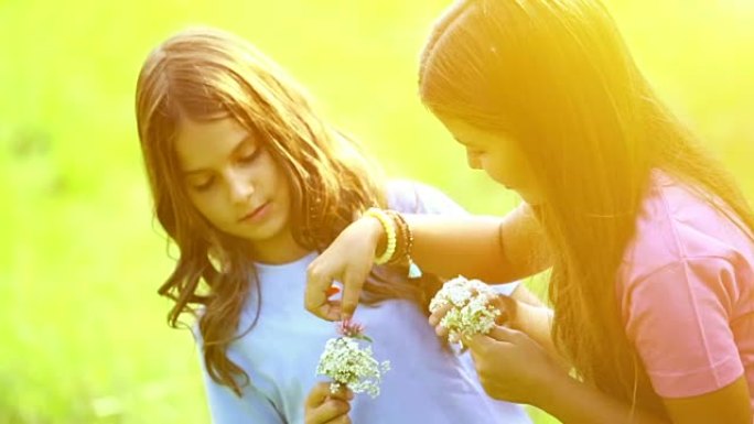 两个女孩在户外采花。