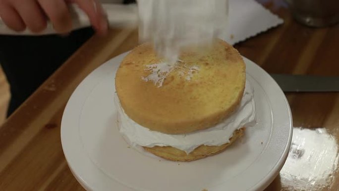 厨师在蛋糕上涂抹奶油