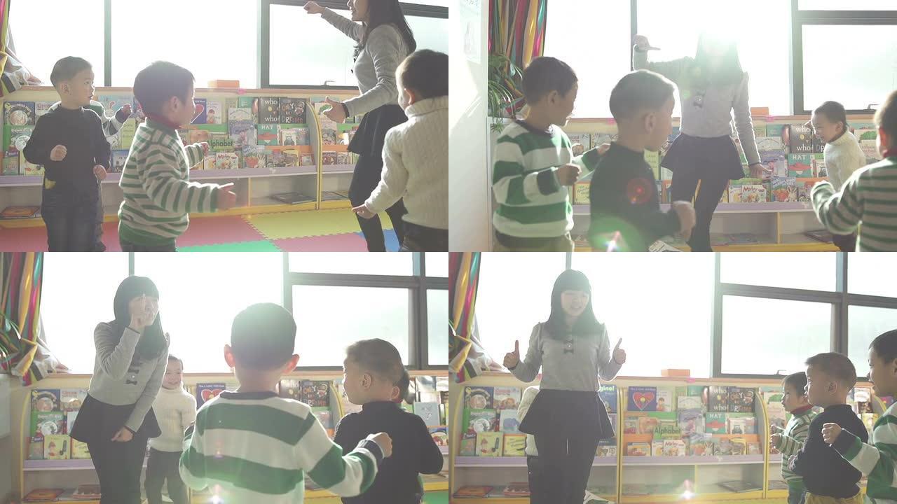 亚洲幼儿教师在教室里和孩子们玩游戏，慢动作。
