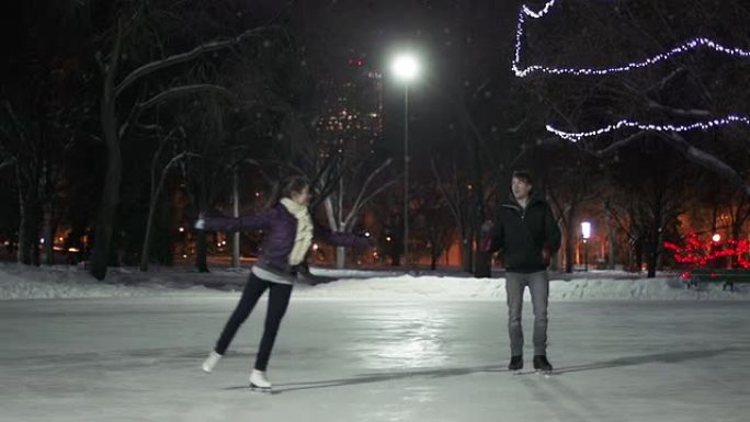 夫妇在一个下雪的冬天晚上有滑冰约会。