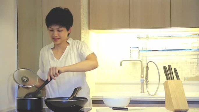 高清: 年轻女性在厨房做饭