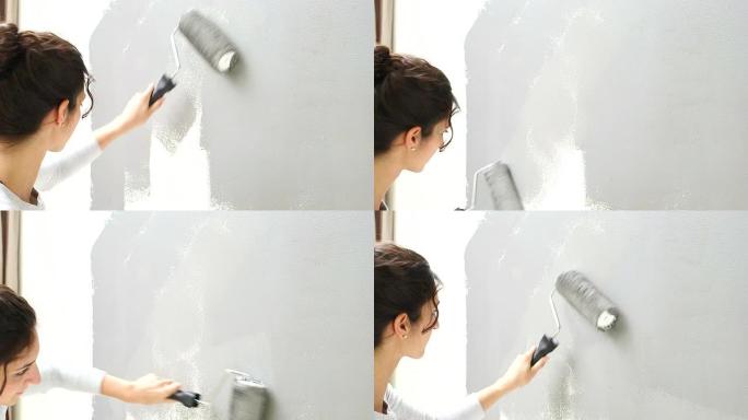 年轻女子正在用油漆滚筒刷墙