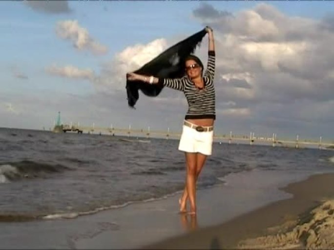 windyd日海滩上的年轻女子