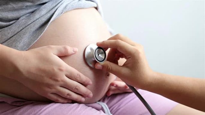 医生用听诊器听到孕妇的肚子