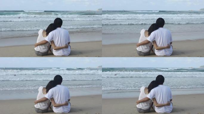 这对亚洲情侣搂着对方的腰，坐着看海。