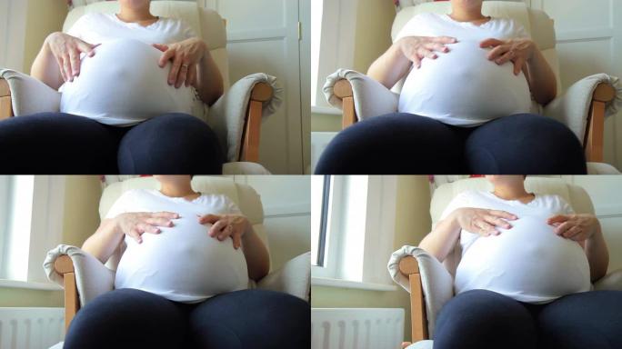 孕妇抚摸着自己的肚子。高清