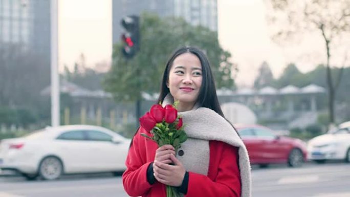 美丽的亚洲女孩手捧一束红花
