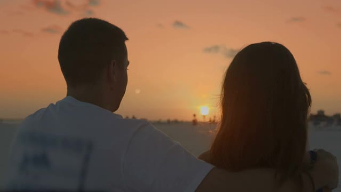 慢镜头爱情年轻情侣在日落海滩接吻