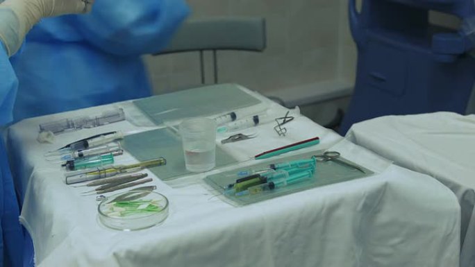 手术室护士用医疗工具将注射器放在桌子上