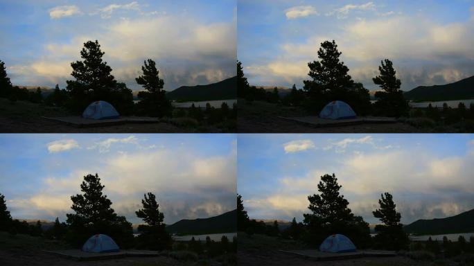 随着太阳的落山和云层营造出高山的光芒，露营帐篷独自站立。