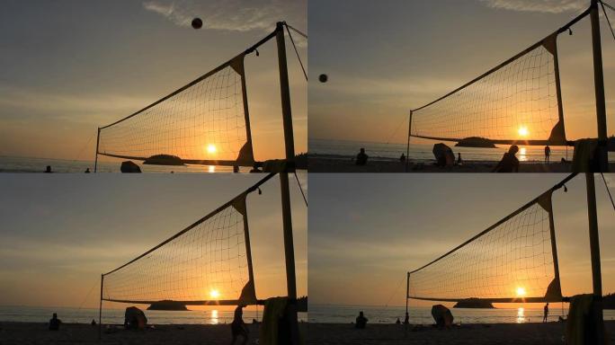 日落时沙滩上排球运动员的剪影