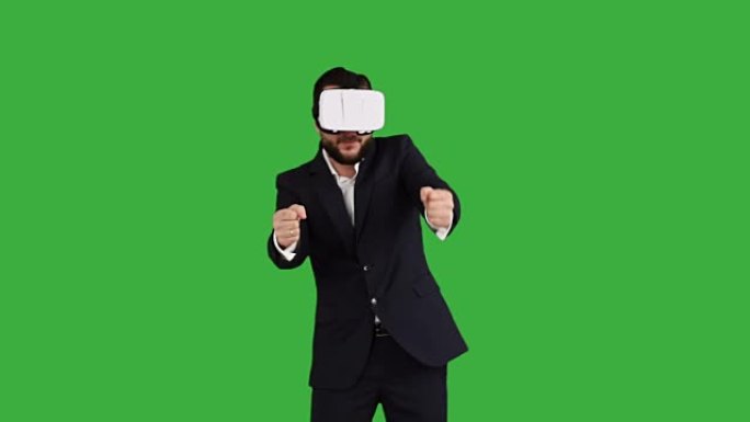 热情的大胡子商人在绿色背景上玩虚拟现实眼镜