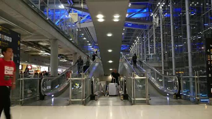 在机场航站楼使用自动扶梯的人群夜间流逝