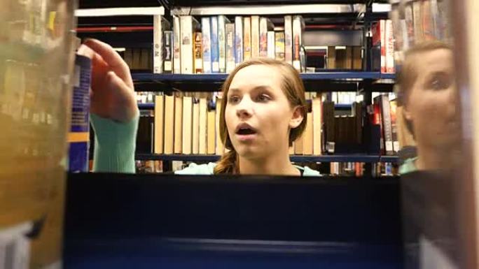 漂亮的女性高加索家庭高中学生在公共图书馆寻找书籍