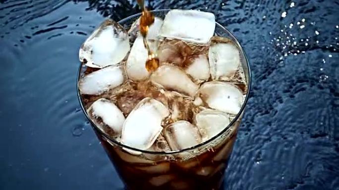 可乐苏打水倒入黑色背景上的慢动作飞溅的冰块中