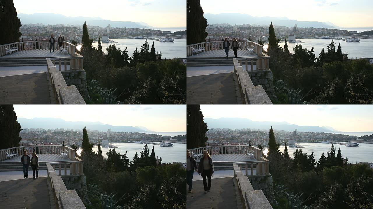 情侣从城市上方的观景台走下台阶