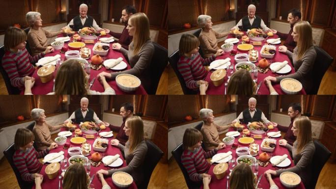家人在感恩节餐桌上祈祷