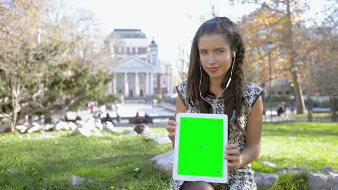 年轻女孩展示绿屏平板电脑