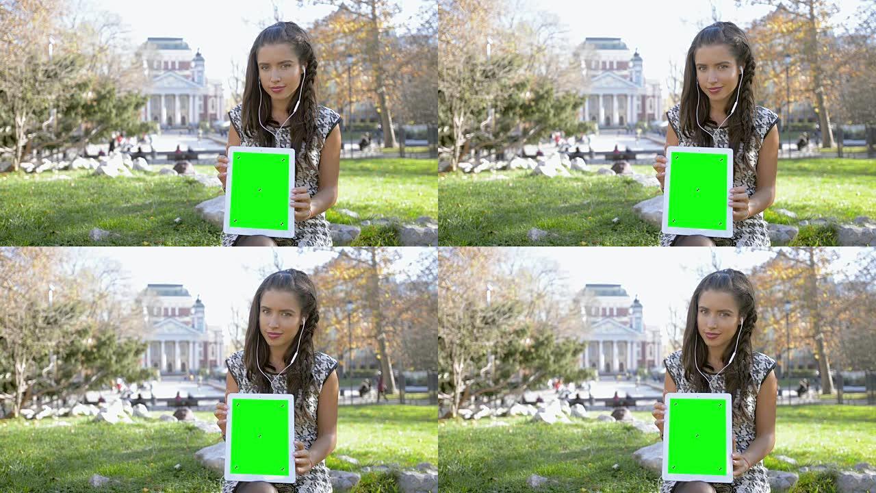 年轻女孩展示绿屏平板电脑