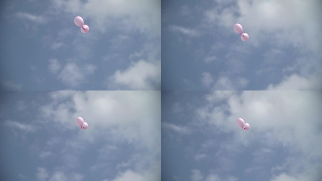 宽镜头低角度两个粉红色的气球飞向天空