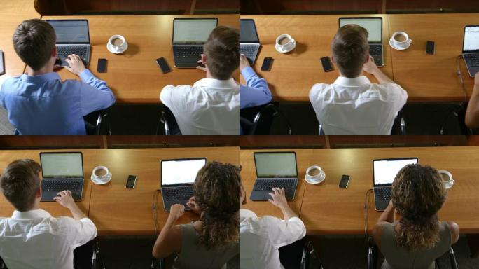 销售团队在办公桌前使用手机和电脑。