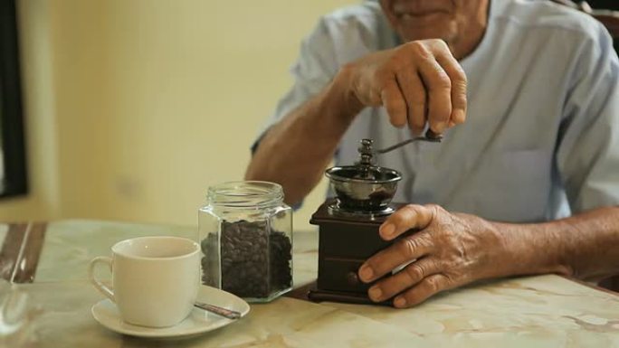 亚洲高级男子，带老式咖啡研磨机