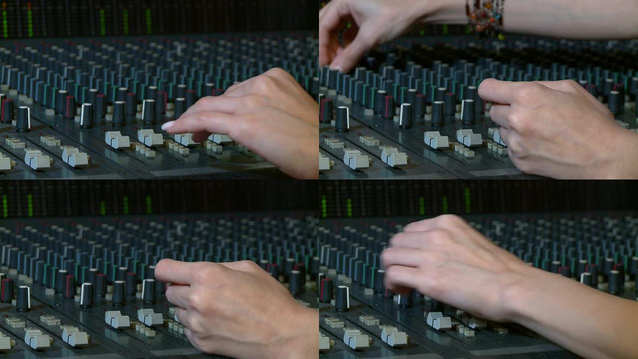 漂亮的手在一个音频控制台