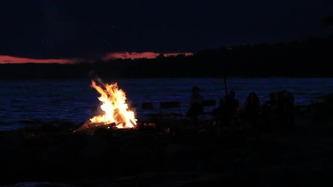 日落时的夏季篝火和湖泊