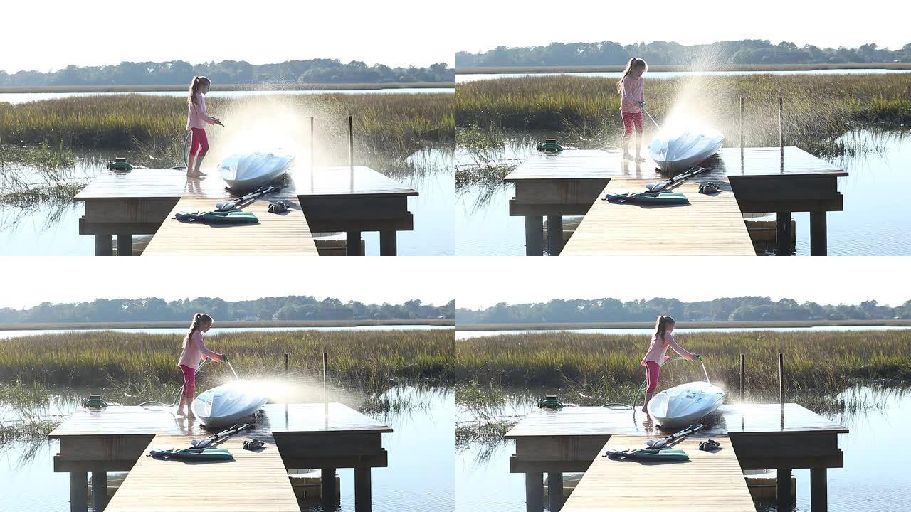 日落时分，一名8岁女孩在码头上喷洒她的皮划艇