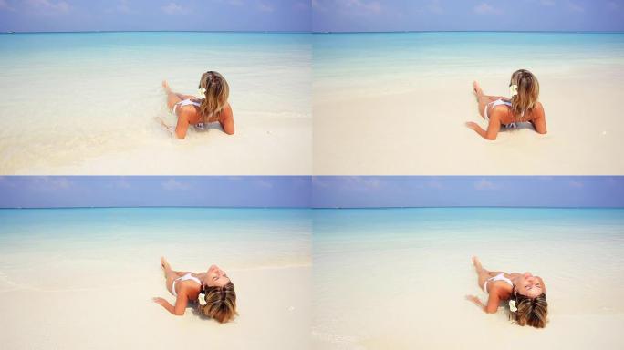 在马尔代夫海滩上放松和晒日光浴的女人。