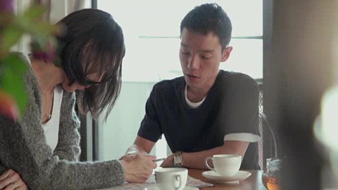 4K，选择性聚焦。年轻的父亲和母亲在客厅里聊天。日本东京