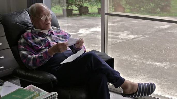 一位亚洲老人在读一封信