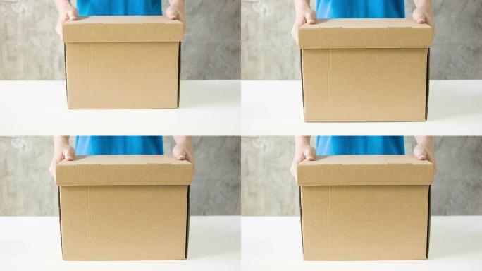 送货员拿着一个纸箱。