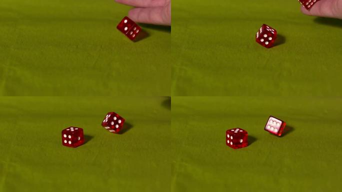 手在绿色桌子上扔两个红色骰子