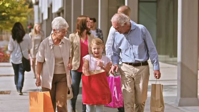 DS的祖父母和孙女手里拿着购物袋