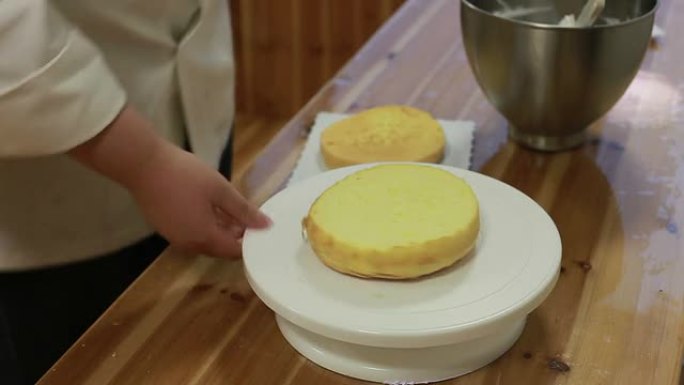 厨师将蛋糕切成两半，然后涂上奶油