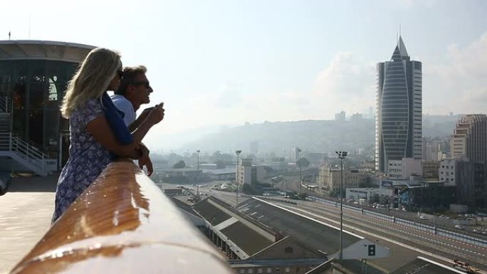 以色列海法，一对夫妇在船栏杆外眺望下面的城市