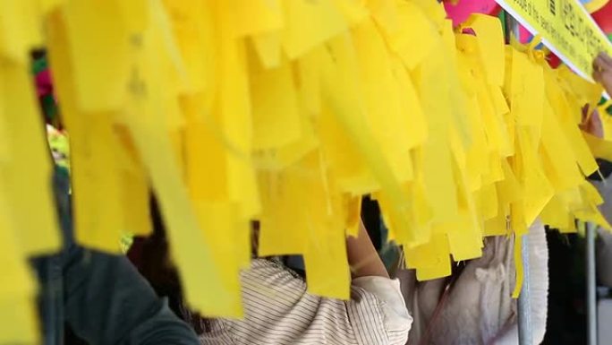亚洲人写黄色标签布祈祷他们的愿望