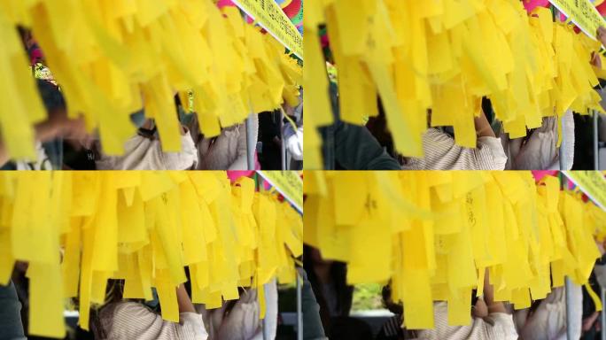 亚洲人写黄色标签布祈祷他们的愿望