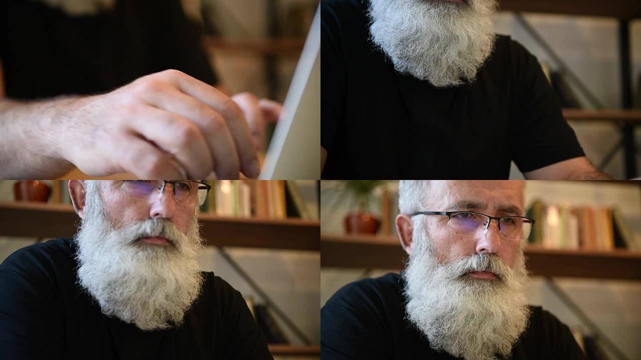 在笔记本电脑上工作的成年大胡子男子
