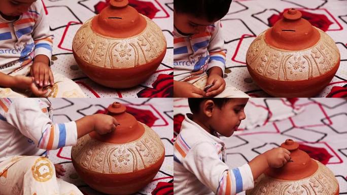 小宝贝玩硬币和粘土Gullak (存钱罐)。