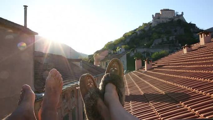 夫妇的脚在中世纪的屋顶露台上放松的细节