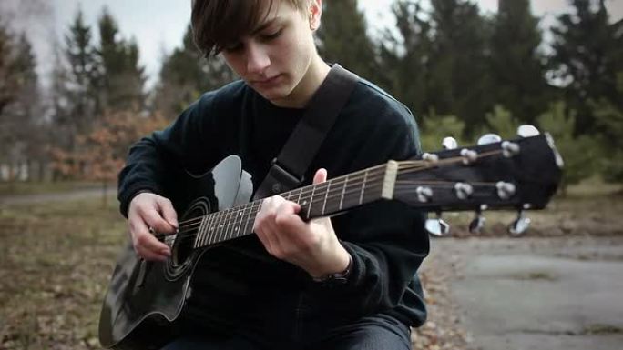 一个年轻人在公园里弹吉他