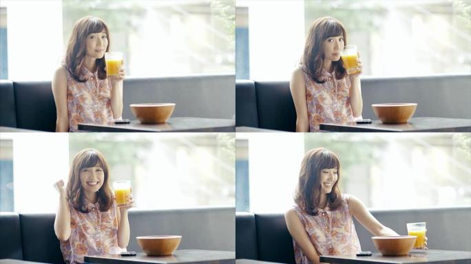 高飞可爱的亚洲女孩在自助餐厅喝果汁