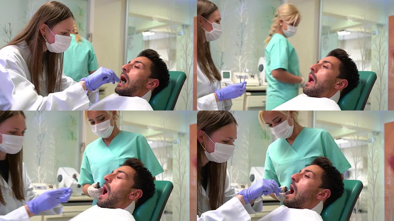 女牙医用口镜检查病人的牙齿。